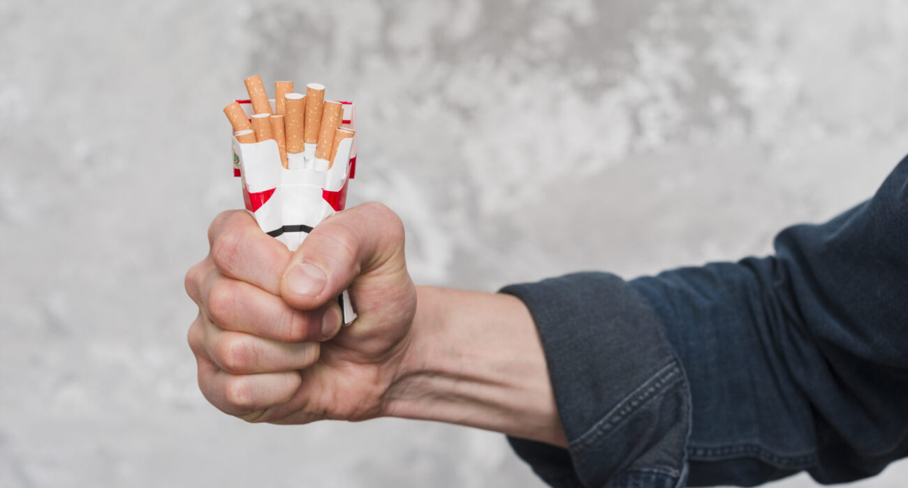 close-up-man-s-hand-crushing-packet-cigarette