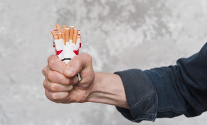 close-up-man-s-hand-crushing-packet-cigarette